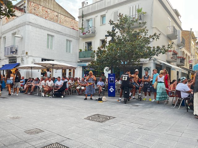 Main Street with people enjoying a drink and watching people walk by