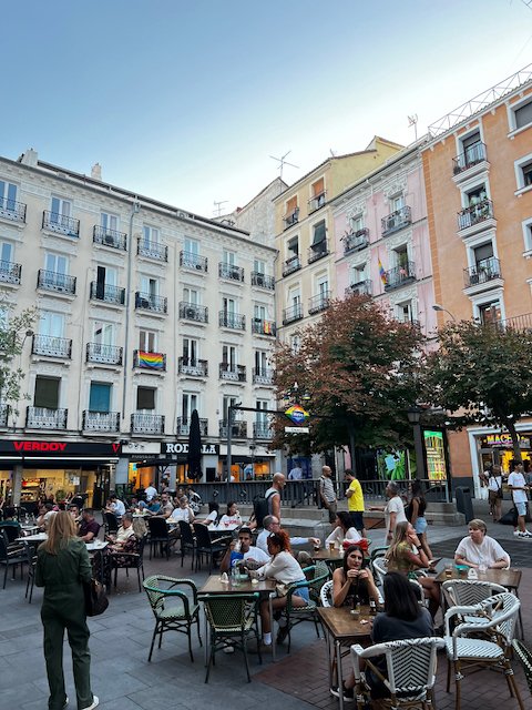 Square in Chueca with outdoor tables and people socializing